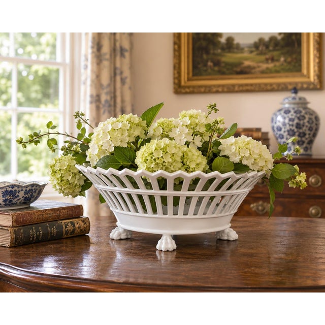 An elegant early 20th-century French porcelain cachepot with a flared oval form, crisp white glaze, and beautifully...