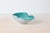 A hand-blown Murano art glass bowl featuring a white cased base with a translucent aqua bullicante rim and sculptural...