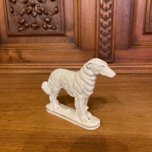 A beautiful Staffordshire pottery style figure of a borzoi or Russian Wolfhound. White with gold gilt accents.
