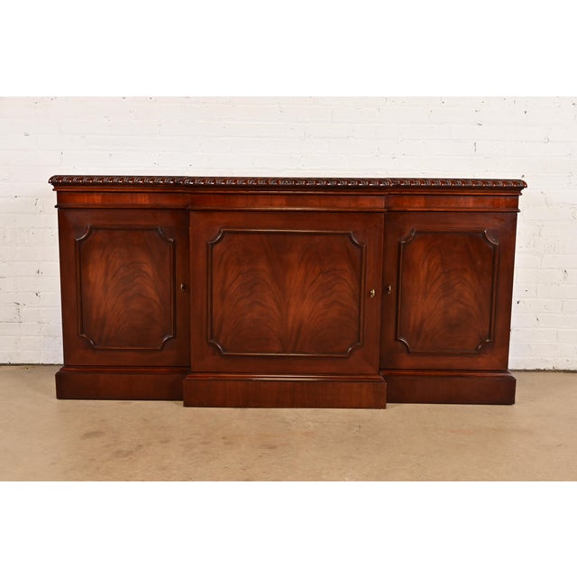 A gorgeous Georgian or Chippendale style breakfront sideboard buffet, credenza, or bar cabinet By Baker Furniture,...