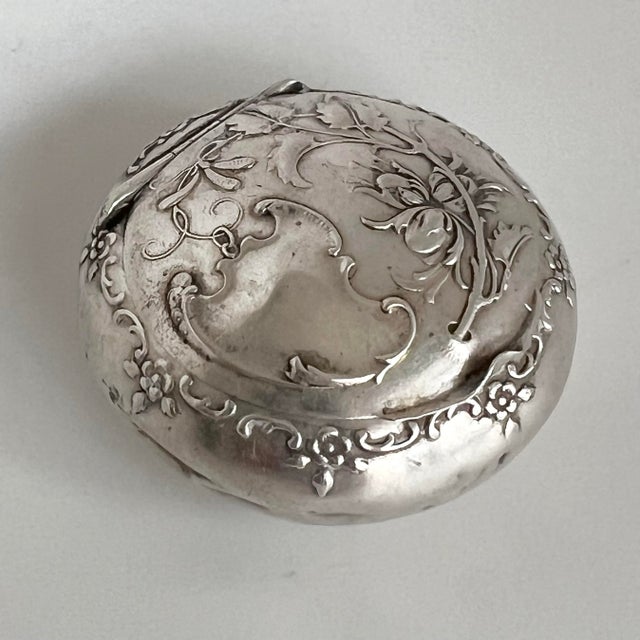 Elegant antique Art Nouveau pill box crafted in solid silver (800), featuring a finely repoussé floral design with...