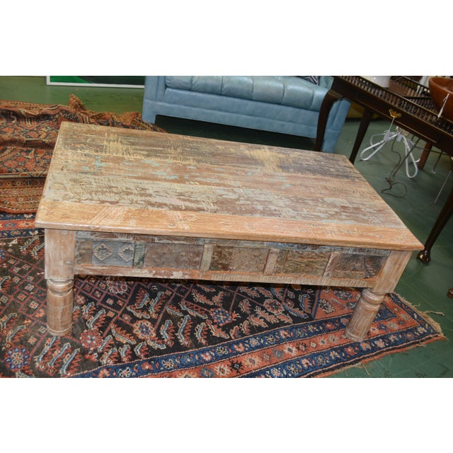 This is a very heavy / substantial wooden coffee table. A shabby / rustic look with numerous colors & a chippy appearance....