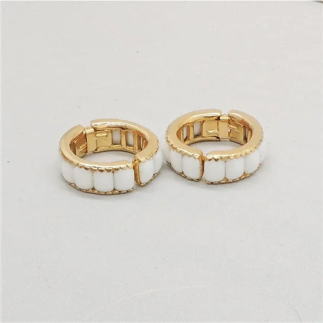 This is part of Chairish’s Costume Jewelry assortment. 1960s goldtone emerald cut white rhinestone hinged hoop clip...