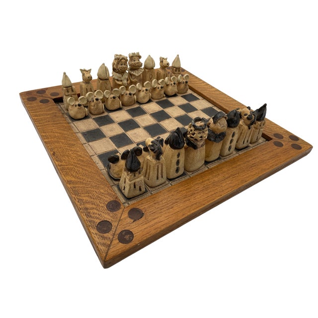This figural terracotta chess set brings together 32 chess pieces and an oak-framed board. Cream and black accents...