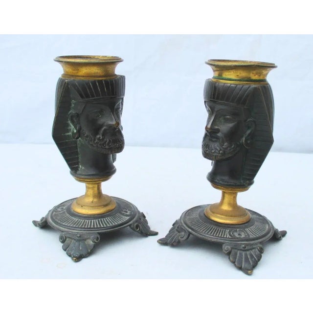 Pair of bronze Egyptian Pharaoh heads on elaborate Greek-style footed bases. Dark bronze patina with gilt candle holder...