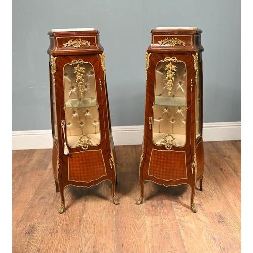 A superb pair of french louis xv style vitrines or display cabinets, richly mounted in gilt bronze and finished with...