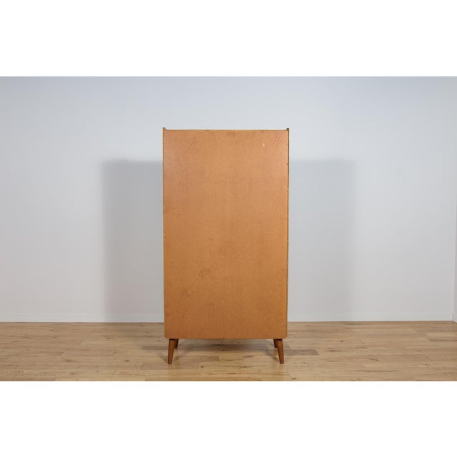 The teak wood bookcase was manufactured in Denmark in the 1960s. The upper section features five open shelves (shelf...