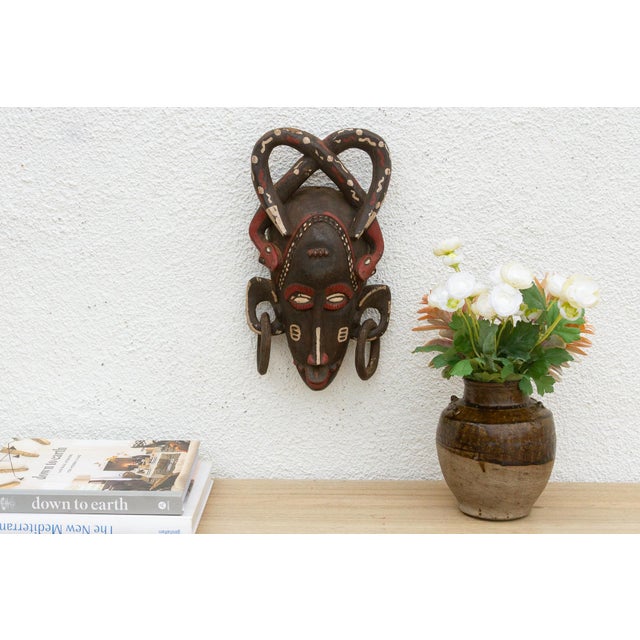 This striking mask, with its bold geometric patterns and avian-inspired design, speaks of a rich cultural heritage and...