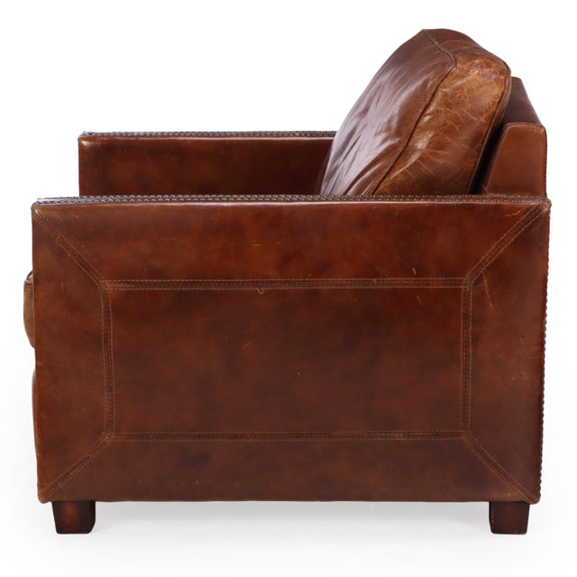 A classic pair of leather club chairs featuring warm, aged leather upholstery. The generous proportions, gently squared...