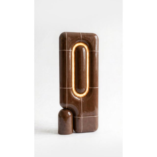 The vertical one. Where the rest of the collection sits low and grounded, this table lamp rises in a slim column of curved...