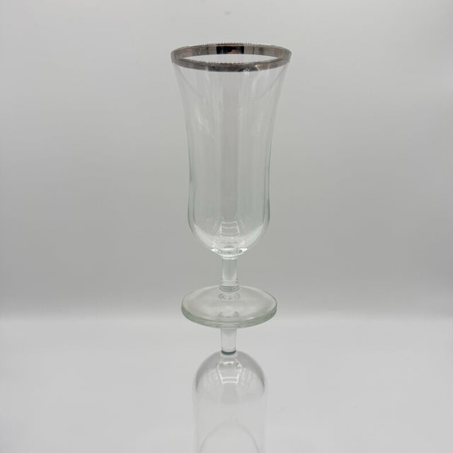 A lovely set of six vintage Paree-style hurricane cocktail glasses featuring elegant, flared silhouettes and gleaming...