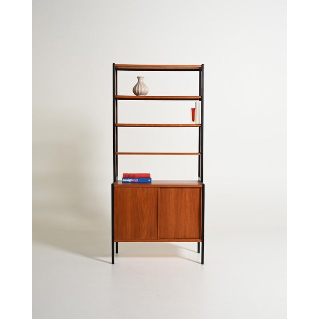 Teak bookcase with black lacquered frame and storage compartment with sliding doors. "Variett" model designed by Bertil...