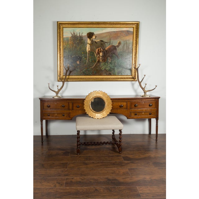 A French vintage giltwood sunburst mirror from the mid-20th century, with rays of slightly varying sizes, carved frame and...