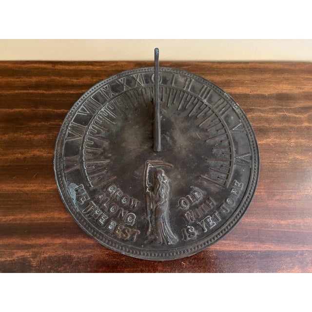 A classic vintage iron verdigris garden sundial inspired by traditional English estate landscapes, reading "Grow old along...