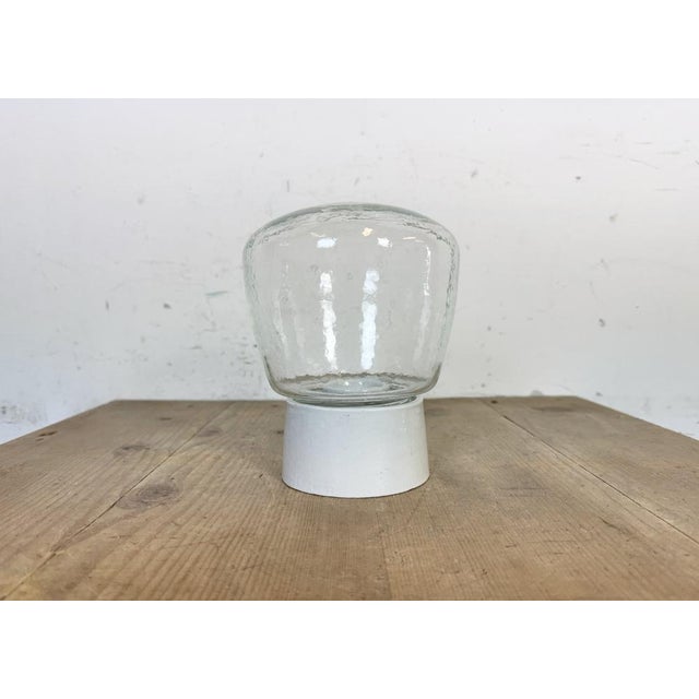 Vintage industrial ceiling or wall light made in former Czechoslovakia during the 1970s. It features a white porcelain...