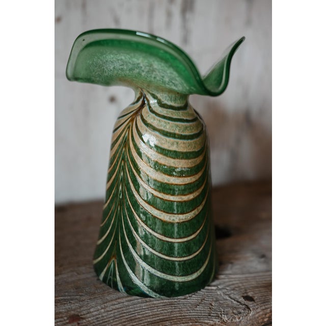 A stunning piece of early 20th-century art glass - this hand-blown green vase features mesmerizing iridescent threading in...