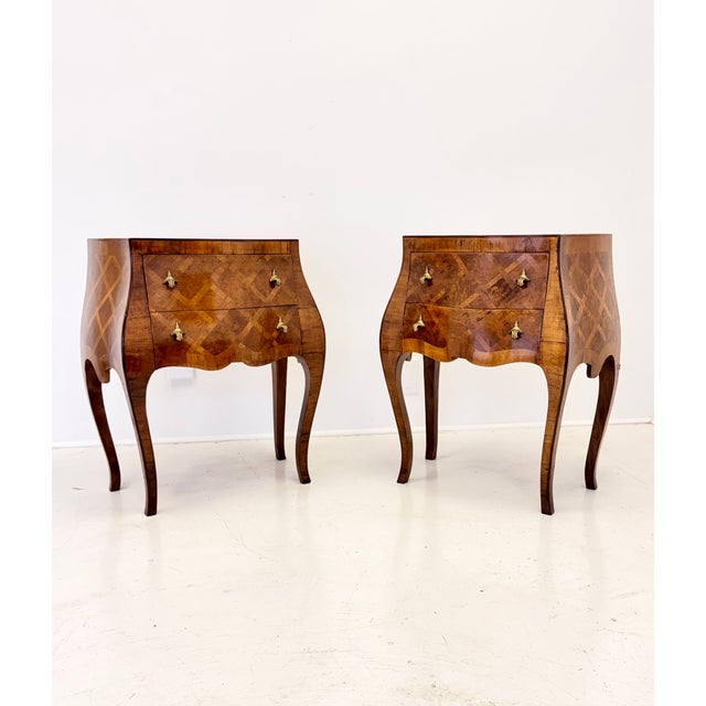 A charming pair of Italian bombe commodini featuring richly figured wood veneers and intricate geometric marquetry. Dating...