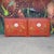 Baker chinoiserie red lacquered case with two hinged doors featuring stylized painted images and ornate hinges, divided...