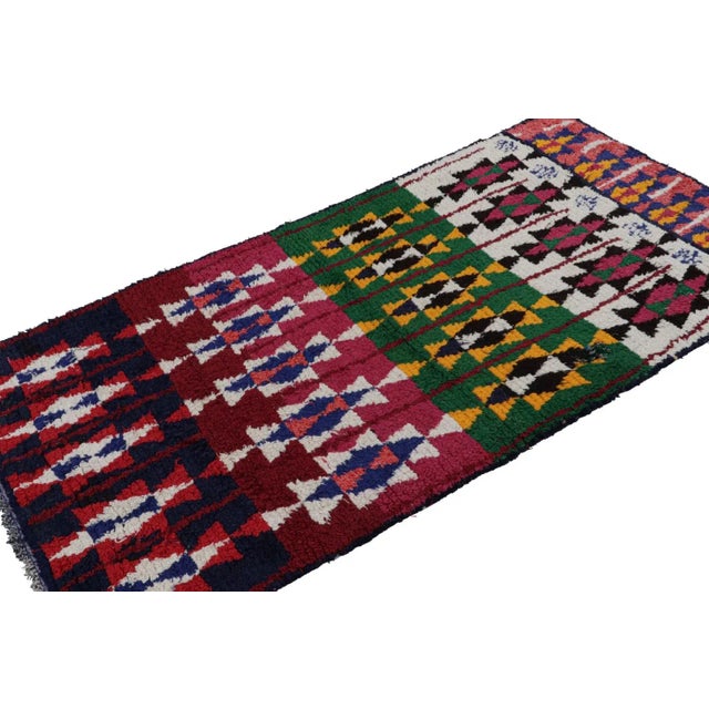 Hand-knotted in wool and fabric circa 1950-1960, this vintage 4x8 Moroccan Boucherouite rug is believed to hail from the...