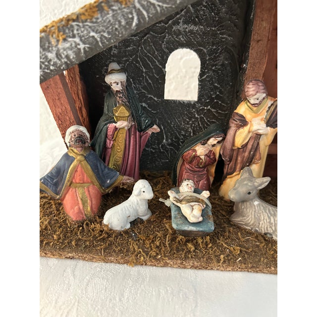 Charming one-piece Christmas nativity scene featuring a wood manger with eight molded resin, hand-painted figures, (three...