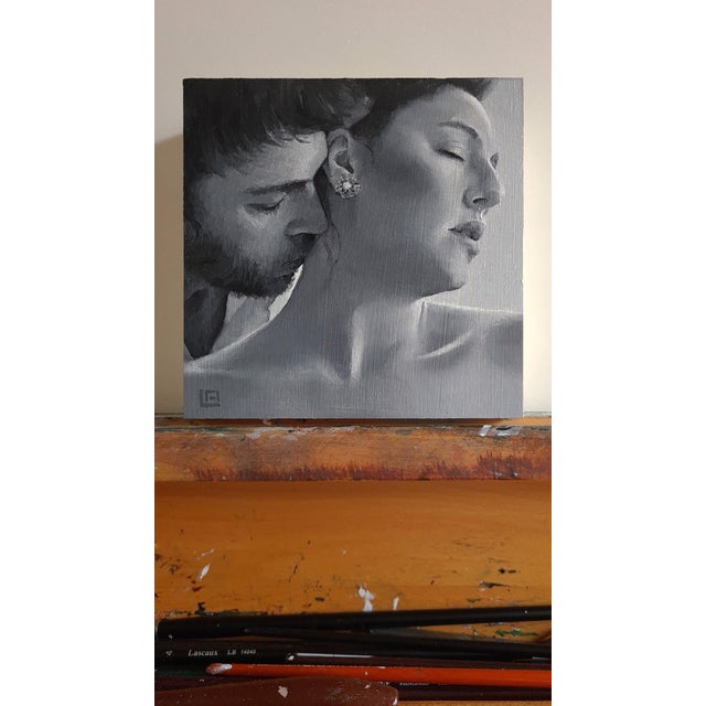 This intimate oil painting captures a tender moment between two figures, focusing on the soft interplay of light and...