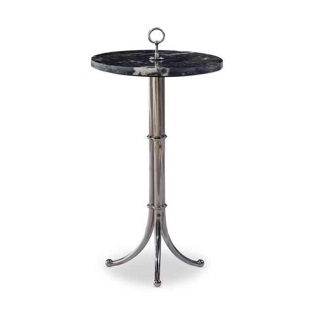 Refined and sculptural, this sleek accent table blends sophistication with a touch of whimsy. A polished metal tripod base...