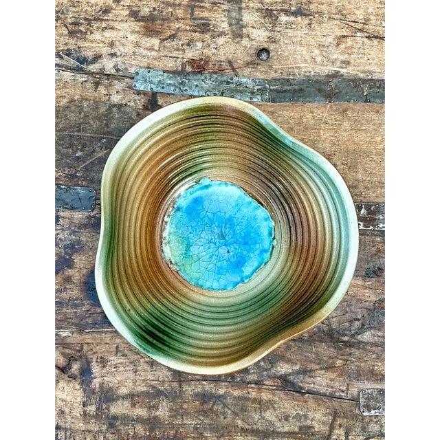 This vintage studio pottery bowl showcases a mesmerizing, painterly glaze composition centered around a vivid turquoise-...