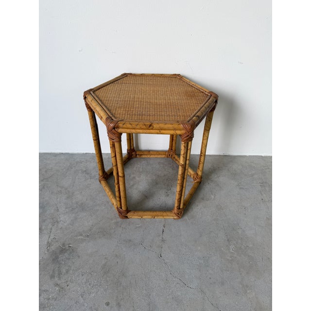 Beautiful Vintage Bamboo and Rattan side table featuring a distinctive hexagonal form and a finely woven rattan top. The...