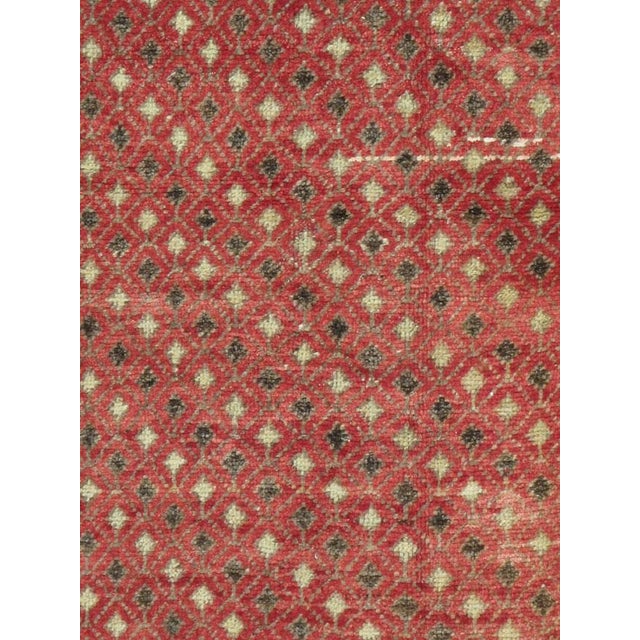 This mid-20th-century Turkish Anatolian carpet presents a dense allover lattice of tiny diamonds across a warm coral-red...