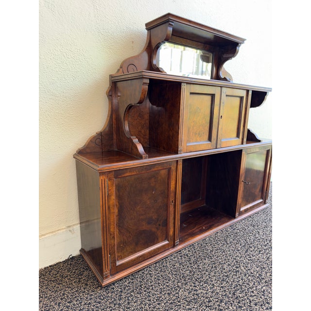This listing is for an antique English wall cabinet or hutch. The cabinet dates to the Victorian era. It features burled...