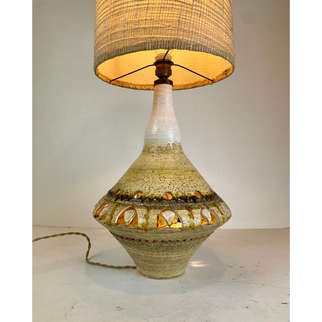 Beautiful Mid-Century Modern table lamp crafted in textured ceramic with distinctive hand-cut geometric openings. Its...