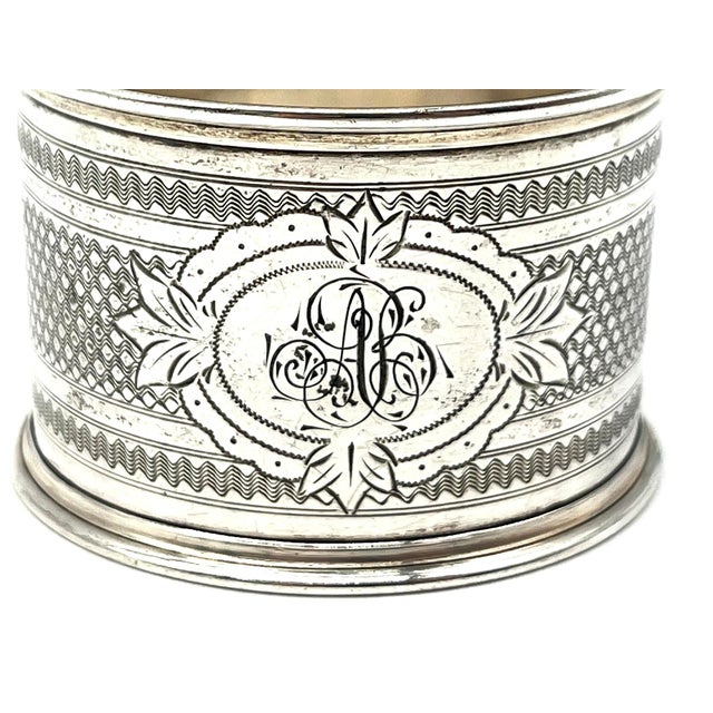Elegant napkin ring in 800 silver with a delicate, engraved design. The piece features detailed floral elements and an...