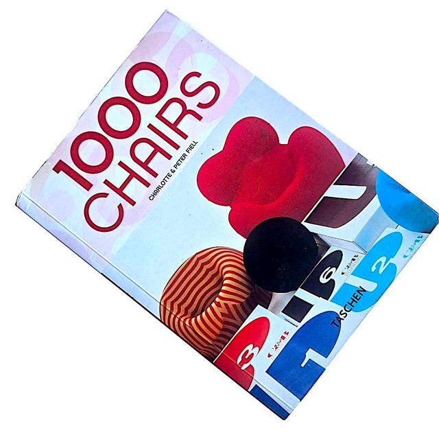 Offered is a 25th anniversary re-edition of the iconic design book "1000 Chairs" by Charlotte and Peter Fiell. Considered...