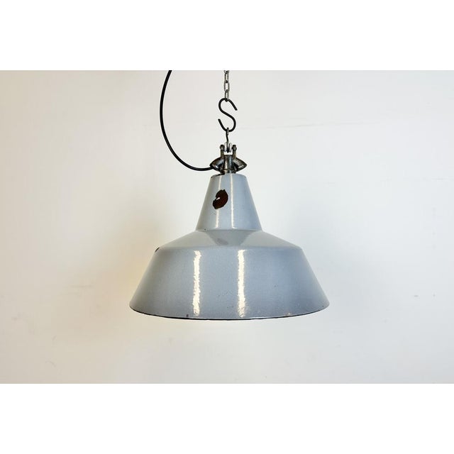 Industrial grey enamel factory pendant light made in Netherlands during the 1960s. White enamel inside the shade. Cast...