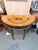 An exceptional antique Neoclassical demilune console table showcasing elaborate marquetry and classical architectural...