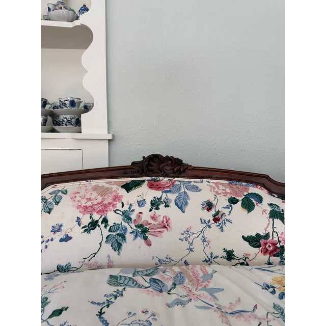 This charming, vintage settee is upholstered in Lee Jofa's Floral Bouquet fabric. The elegant frame has carved details...