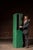Tall two-tier steel locker cabinet in original green paint, featuring vented doors and simple latch hardware. The unit is...