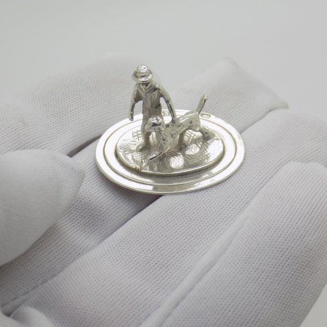 This vintage silver miniature depicts a traditional dutch man standing beside his dog, crafted as a desktop display...