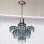 A Lightolier chandelier by Italian designer Gaetano Sciolari. It features nine glass shades with polished nickel body.