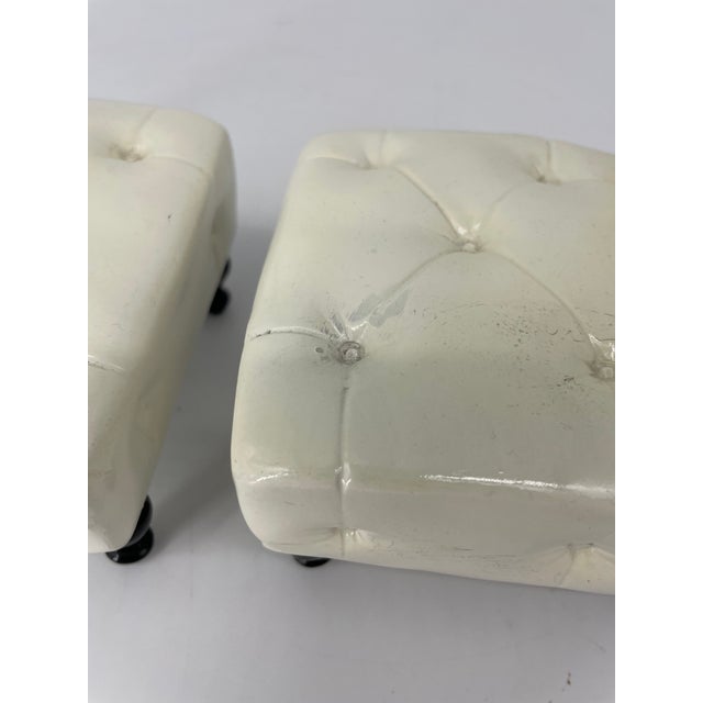 These are super cute bookends that will add style to any shelf! They depict a pair of white tufted seats set on four legs.