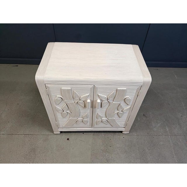 Elegant split or pencil reed cabinet with two doors feauturing a bamboo shaped form. Elegant and tropical looking cabinet...