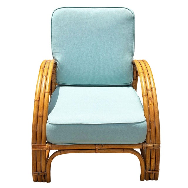This beautifully restored Paul Frankl inspired rattan lounge chair features a triple-strand half-moon arm design with...