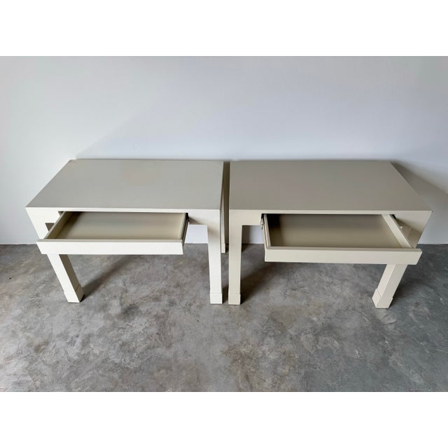 These 1980s Postmodern Parsons-style end tables or nightstands feature a sleek, minimalist design with a raffia cloth-...