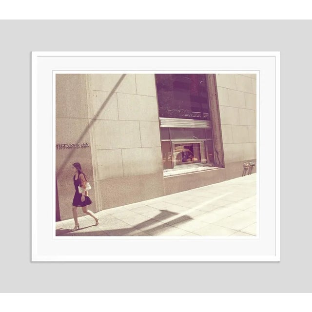 Tiffanys' by stuart möller a young woman passes by the infamous diamond & jewellery store, tiffany’s in new york, with...