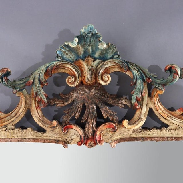 A striking French Louis XIV style polychromed and carved mirror, signed Niccolini and dating to the 20th Century. This...