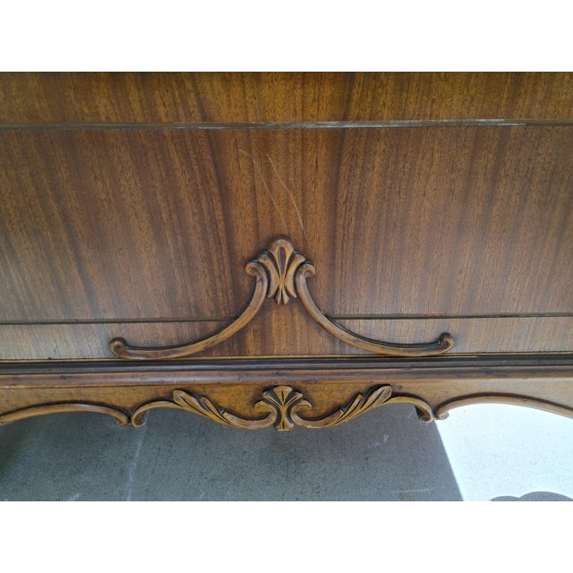 An elegant early 20th-century Victorian Revival chiffonier featuring richly detailed ornamental woodwork, a warm walnut-...
