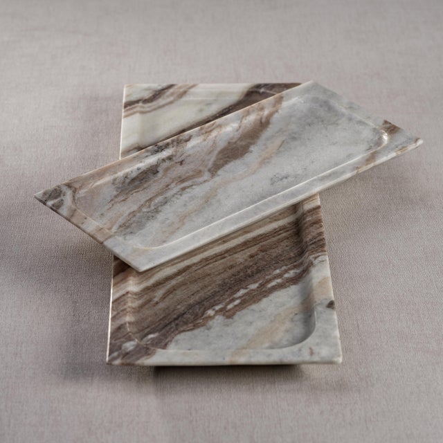 Crafted from premium marble, this tray features a unique rectangular silhouette with elegantly raised edges. The brown...