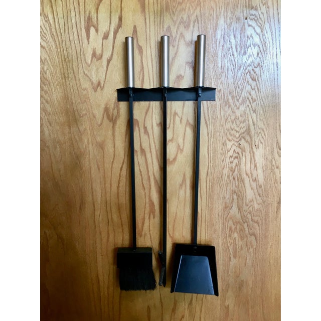 Iron with stainless steel handles hang from a geometric wall mount.