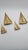 A set of four sailboat figurines from the 1970s, made of solid brass in a warm golden hue. Each figurine has a minimalist,...