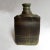 This ceramic bottle vase comes in dark grey and green hues with abstract decor. The piece is signed 'C.B.'